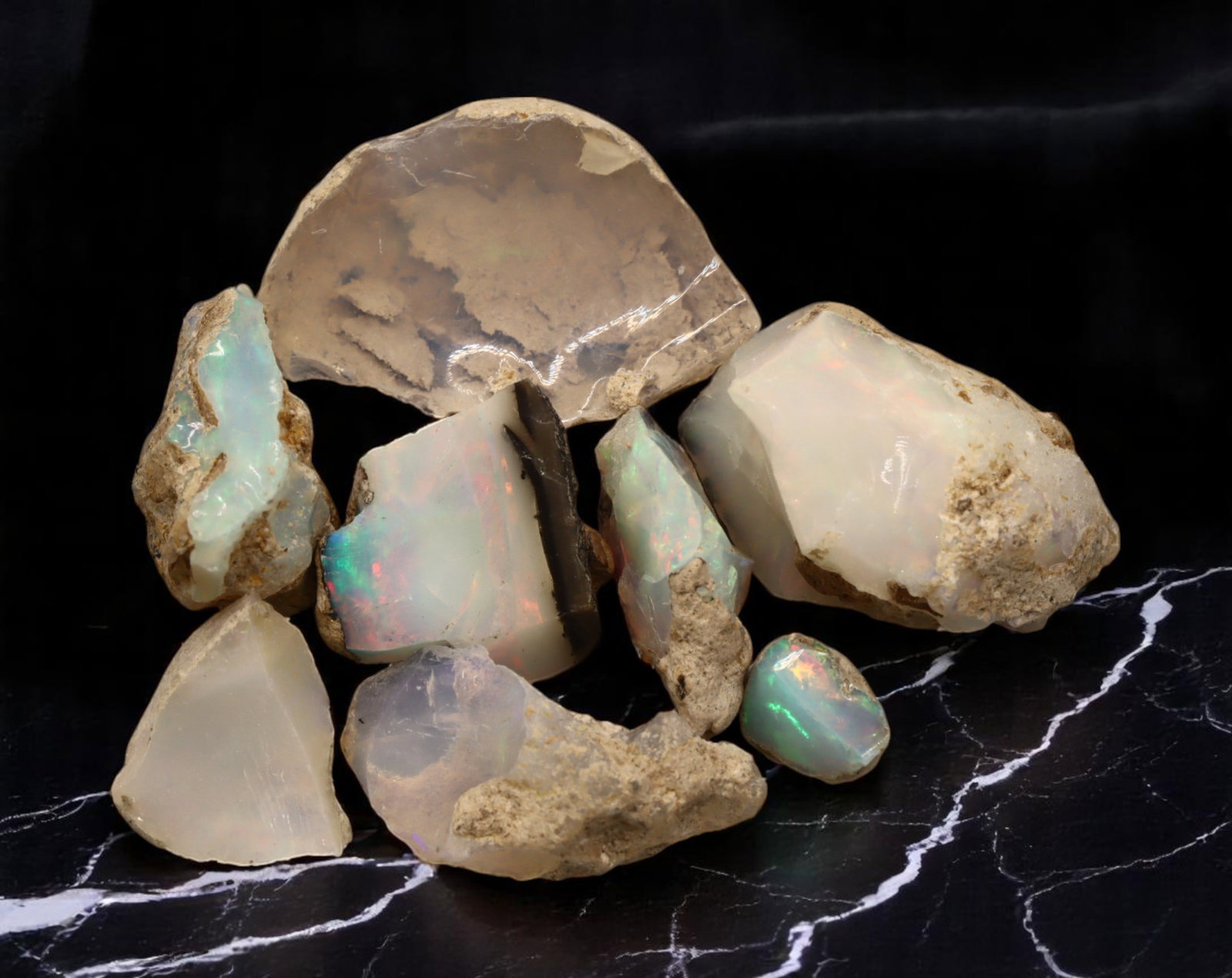 GEM LOT: Ethiopian Welo Opal Rough - Iridescent Play-of-Color in Matrix, Mixed Forms (16g): An estate-sourced parcel of natural Ethiopian Welo Opal rough, totaling 11 grams, this lot features raw, matrix-hosted specimens with vibrant play-of-color across milky, translucent, and honey-toned b