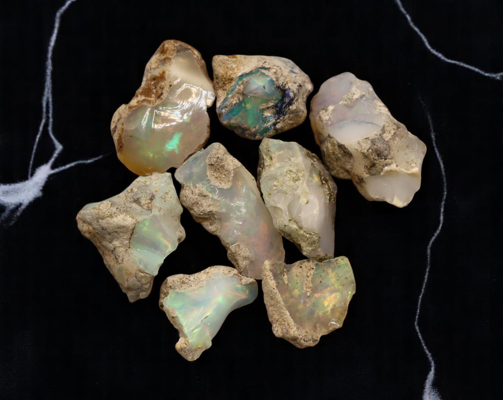 GEM LOT: Ethiopian Welo Opal Rough - Iridescent Play-of-Color in Matrix, Mixed Forms (13g): An estate-sourced parcel of natural Ethiopian Welo Opal rough, totaling 11 grams, this lot features raw, matrix-hosted specimens with vibrant play-of-color across milky, translucent, and honey-toned b