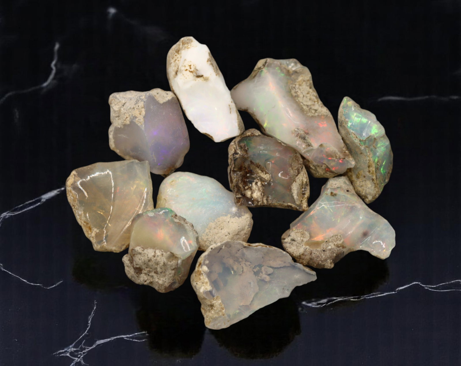 GEM LOT: Ethiopian Welo Opal Rough - Iridescent Play-of-Color in Matrix, Mixed Forms (14g): An estate-sourced parcel of natural Ethiopian Welo Opal rough, totaling 11 grams, this lot features raw, matrix-hosted specimens with vibrant play-of-color across milky, translucent, and honey-toned b