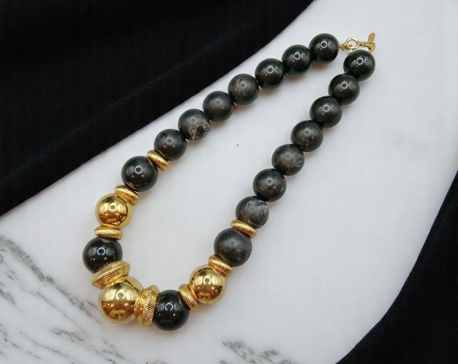 MONET: Designer Bead Necklace - Black & Goldtone Spheres, Textured Spacers, 40 cm: A powerful piece by midcentury American fashion house MONET, this 40 cm necklace commands attention with oversized black beads and reflective goldtone spheres, punctuated by textured rope-style spacer