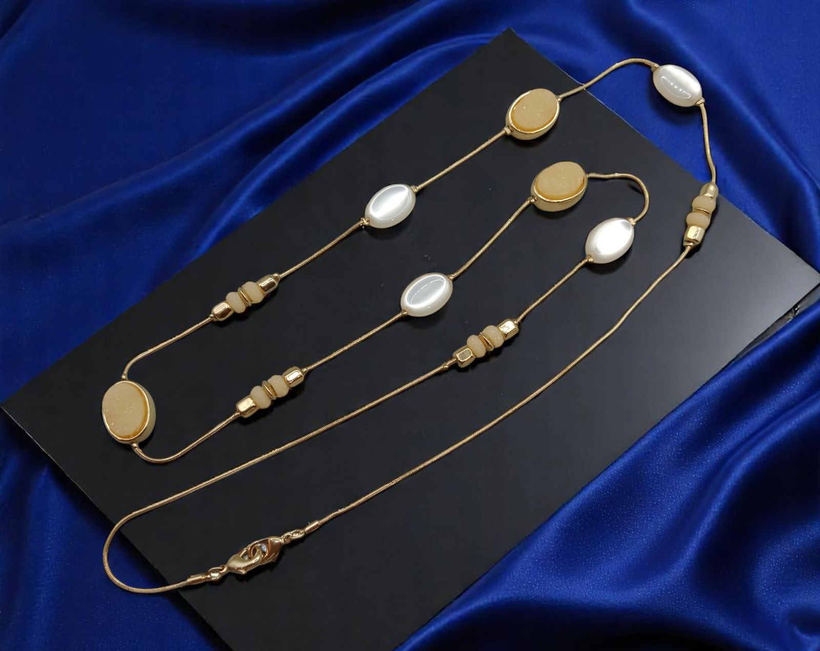 MODERN ROMANTIC: Station Necklace - Pearl-Like & Sand-Toned Beads, Goldtone Finish (80 cm): A softly elegant design with romantic overtones, this long station necklace features alternating pearl-like ovals and sand-colored textured beads set in warm goldtone bezels. The minimalist styling is