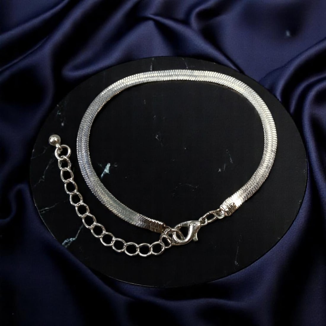 SLEEK MINIMALISM: Silver-Tone Wide Herringbone Chain Bracelet, 17cm: An embodiment of understated sophistication, this 17cm silver-tone bracelet features a bold herringbone chain design that lays flat against the wrist for a smooth, fluid silhouette. The reflective fin