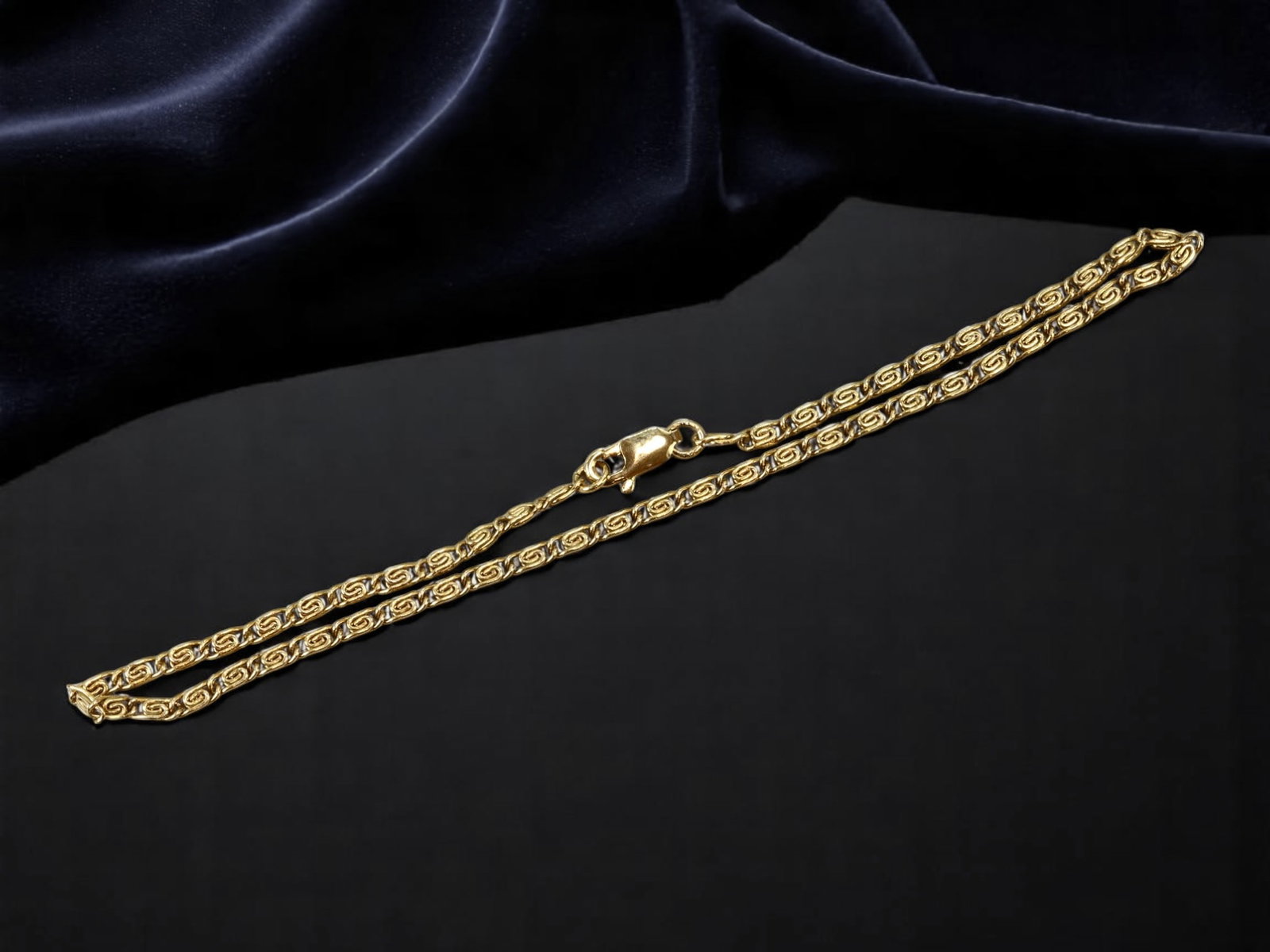 Bracelet/Anklet - Twisted Patterned Goldtone Chain, 24cm: This contemporary chain features a refined twisted link design with repeating scroll motifs, crafted in rich goldtone for a luxurious finish. Measuring approximately 24 cm, it is sized for wear as eit