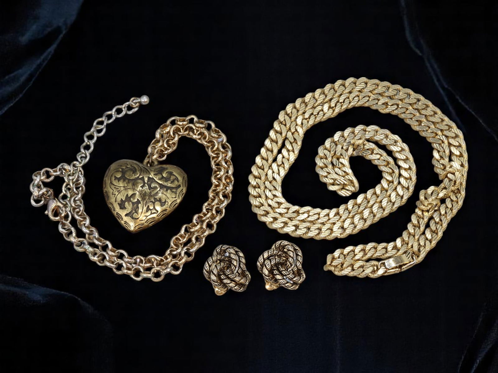 Timeless Romance - Heart Locket & Woven Link Necklaces with Classic Knot Earrings Set: This captivating trio radiates vintage elegance and symbolic beauty. The first necklace features a delicately engraved golden heart locket, emblematic of love and devotion, suspended from an elegantly