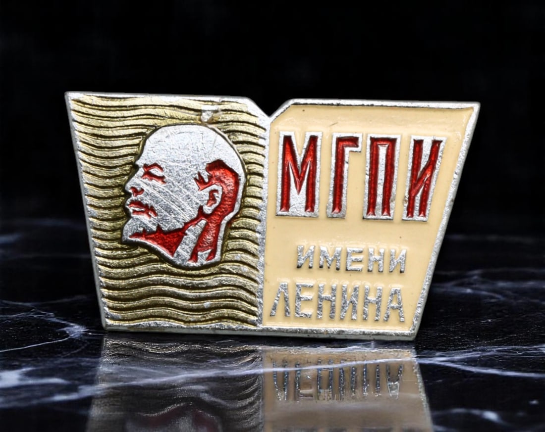 USSR: Lenin Legacy - Moscow State Pedagogical Institute Commemorative Badge, 25x14mm: This distinctive badge celebrates the Moscow State Pedagogical Institute named after Lenin, one of the Soviet Union's premier educational institutions. The sharply stylized profile of Lenin, set again