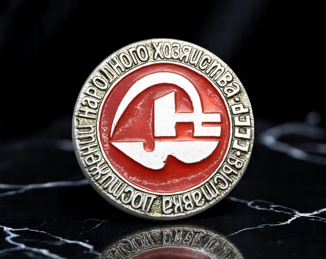 USSR: Order of Labor Merit - Badge of Excellence in National Economy USSR, circa 1970s, 20mm: This bold circular badge symbolizes the Soviet ideal of labor as the foundation of the socialist state. Dominating the design is a stylized hammer and sickle emblem, set against a vivid red enamel bac