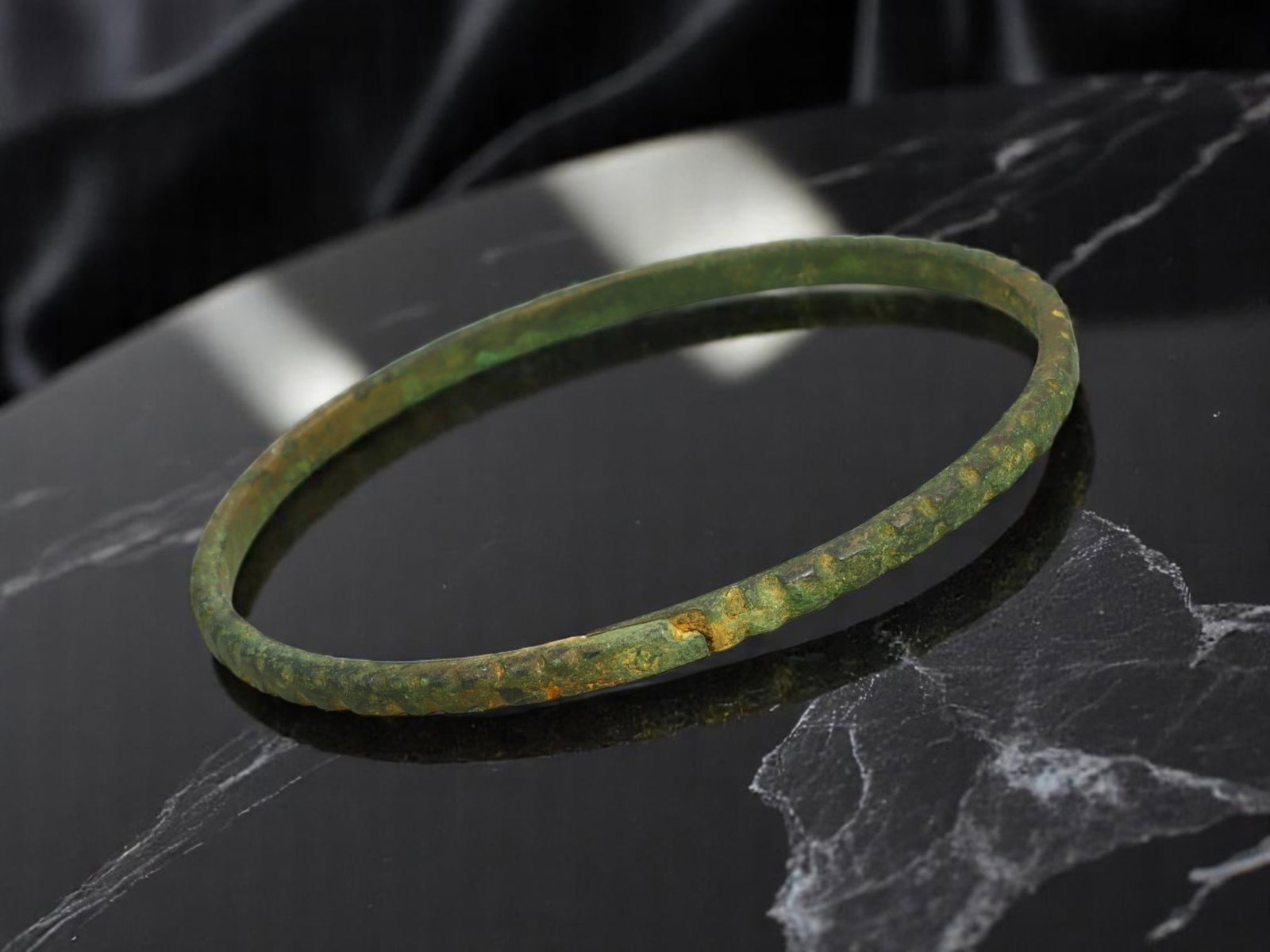 LATE ROMAN / EARLY BYZANTINE Hammered Texture Bronze Bracelet, 6.5 cm: Slim and refined in profile, this circular bronze bracelet features a lightly hammered surface with rhythmic dimpling around the entire band-an artisanal detail typical of provincial workshops during 