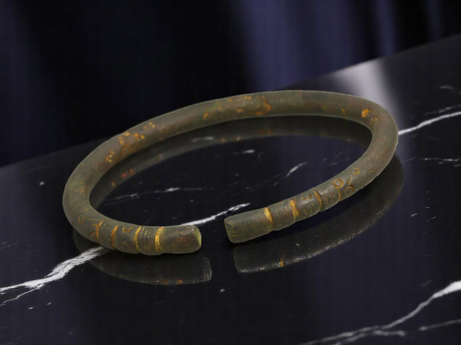 ANCIENT CELTIC / ROMAN PROVINCIAL Segment-Decorated Bronze Bracelet, 8.2 cm: Monumental in scale and rich in surface detail, this open-form bronze bracelet displays triple-segmented terminals with scroll-dot punchwork ornamentation-a classic combination in Celtic and Roman pro
