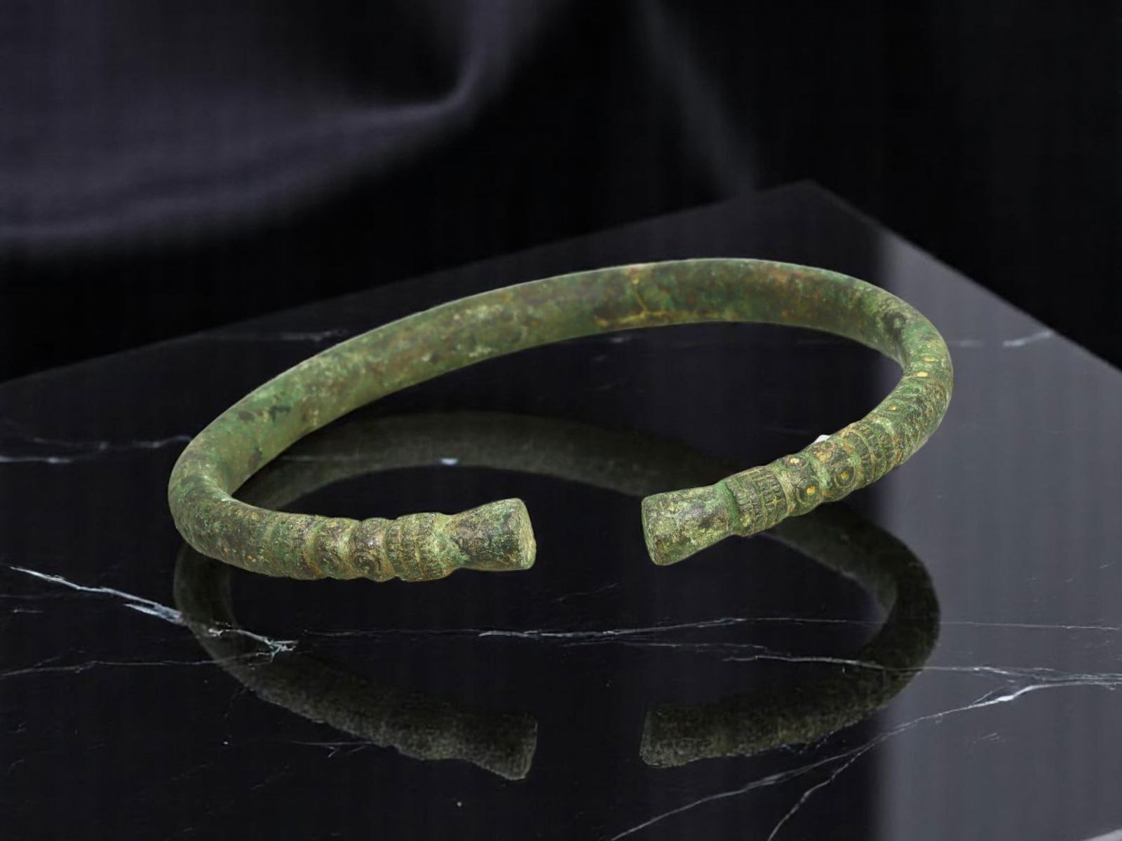 ANCIENT CELTIC / ROMAN PROVINCIAL Punchwork-Decorated Bronze Bracelet, 7.5 cm: With pronounced punchwork and stacked ringed bands flanking both squared terminals, this open-form bronze bracelet exemplifies the embellished craftsmanship of ancient Celtic and Roman frontier metalw