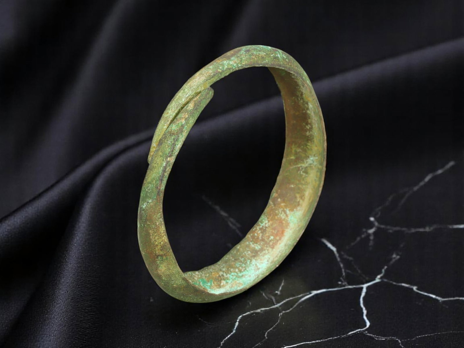 LATE ROMAN / EARLY BYZANTINE Hooked-Terminal Bronze Bracelet, 6.7 cm: Cast in a broad, flattened band with bluntly angled, hooked terminals, this Late Roman to Early Byzantine bracelet reflects the transitional aesthetics of provincial adornment during the 4th to 6th ce