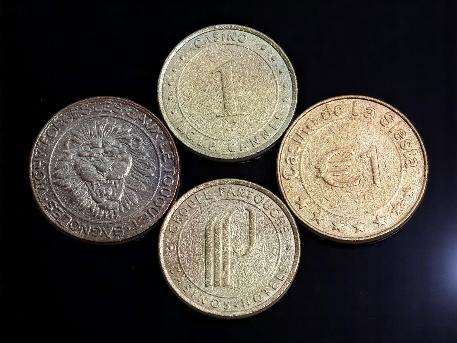 FRANCE: Riviera Casinos - Casino Gaming Token Coin Lot, c.1980s-1990s, 26-28mm: A vibrant assemblage of four French Riviera casino tokens, capturing the golden era of glamour and high-stakes gaming along the Mediterranean coast. This lot includes tokens from iconic establishments
