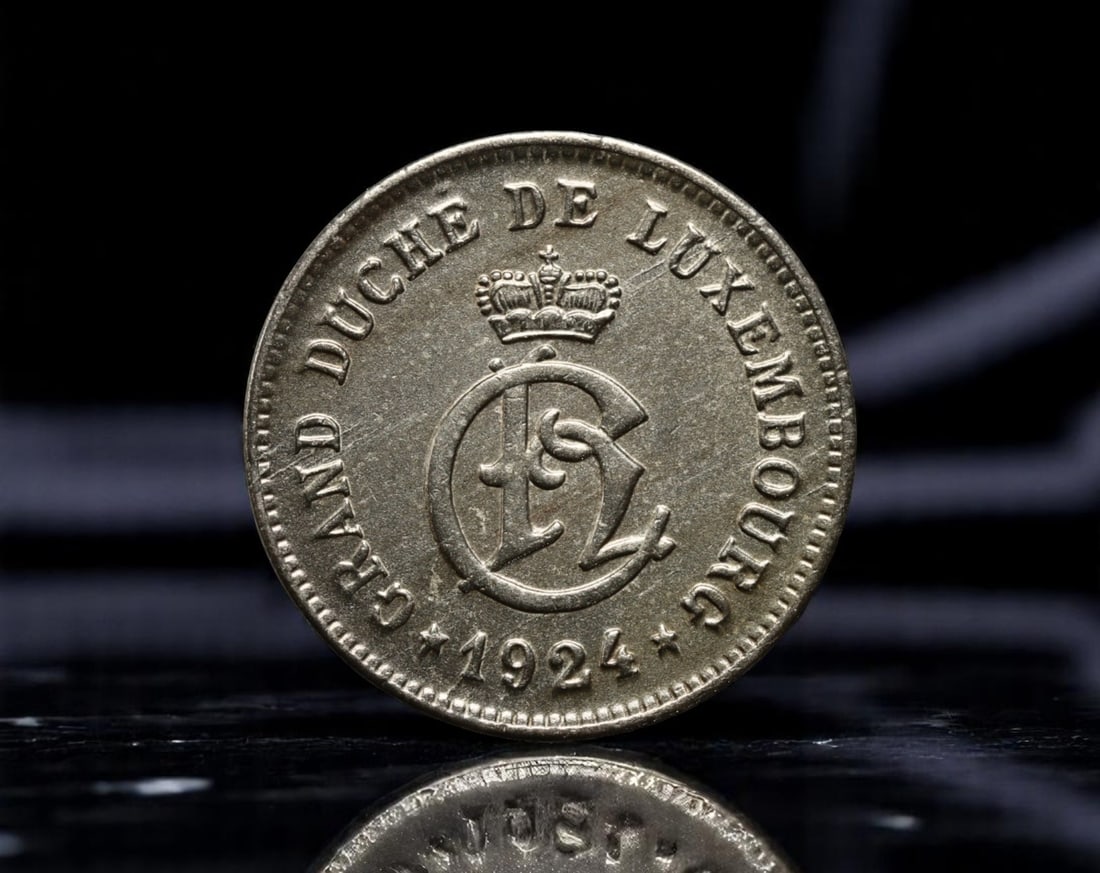 LUXEMBOURG: Grand Duchy Emblem - Charlotte Monogram 10 Centimes Coin, 1924, 20mm: Issued under the reign of Grand Duchess Charlotte, this 10 Centimes coin from 1924 blends the authority of sovereign insignia with early 20th-century European design clarity. The obverse presents a cr