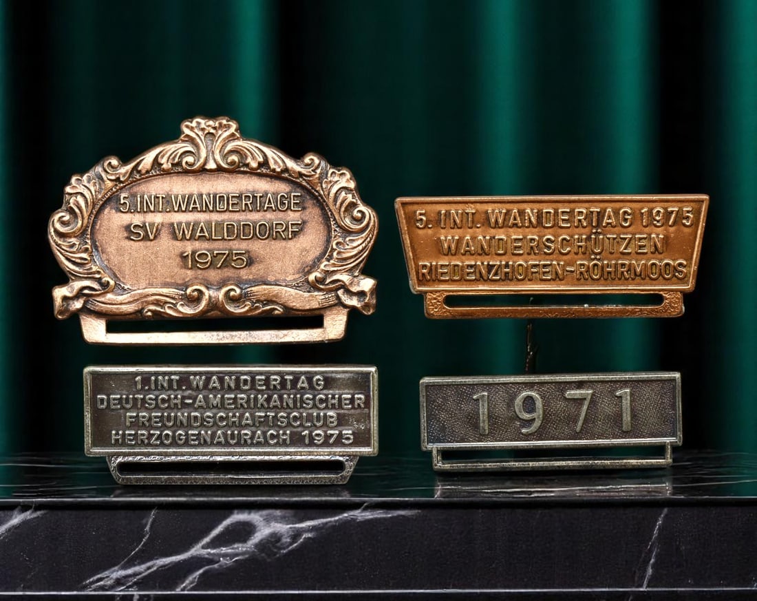 GERMANY: Friendship and Fellowship - Wandertag and Volksmarch Badges, 1971-1975, 33-45mm: Forged in the spirit of transatlantic camaraderie and local tradition, these four commemorative badges represent a vibrant era of grassroots cultural unity in postwar West Germany. Highlighted among t