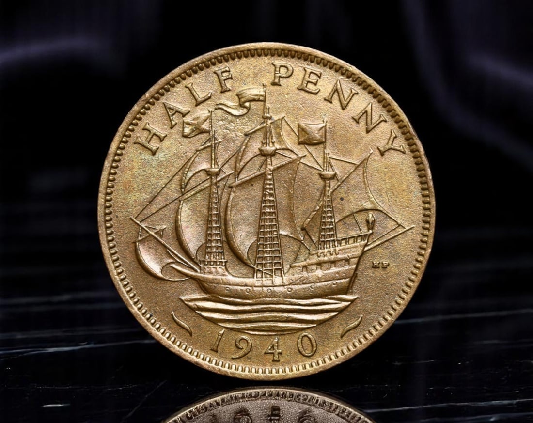 UNITED KINGDOM: King George VI - Maritime Strength Half Penny Coin, 1940, 25mm: Issued during the tumultuous days of World War II, this 1940 Half Penny boldly projects Britain's enduring maritime supremacy. The obverse presents a dignified effigy of King George VI, evoking a sens