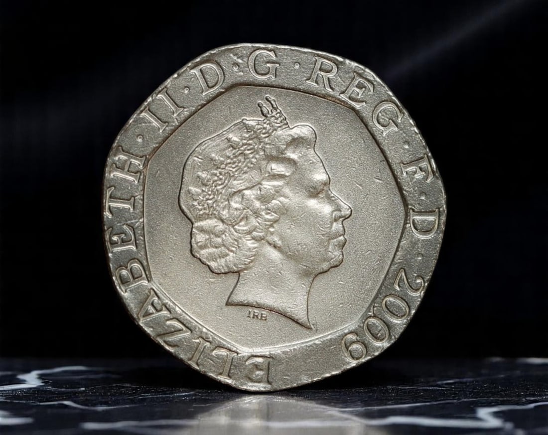 UNITED KINGDOM: Elizabeth II - Royal Arms Series 20 Pence Coin, 2009, 21mm: Issued as part of the radical 2008 Royal Shield of Arms redesign, this 2009 20 Pence coin captures a section of the historic royal crest, innovatively fragmented across multiple denominations to form 