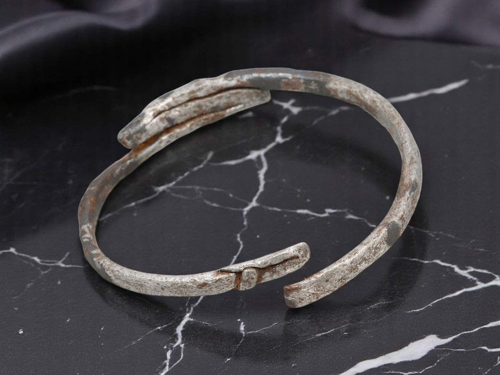 VIKING AGE Iron Bracelet - Flattened Overlap Closure, Rounded Band Form, Weathered Silver-Tone: This early medieval iron bracelet presents a robust circular band form with a distinct overlapping closure, where the forged ends are flattened and subtly grooved for reinforcement. The surface bears