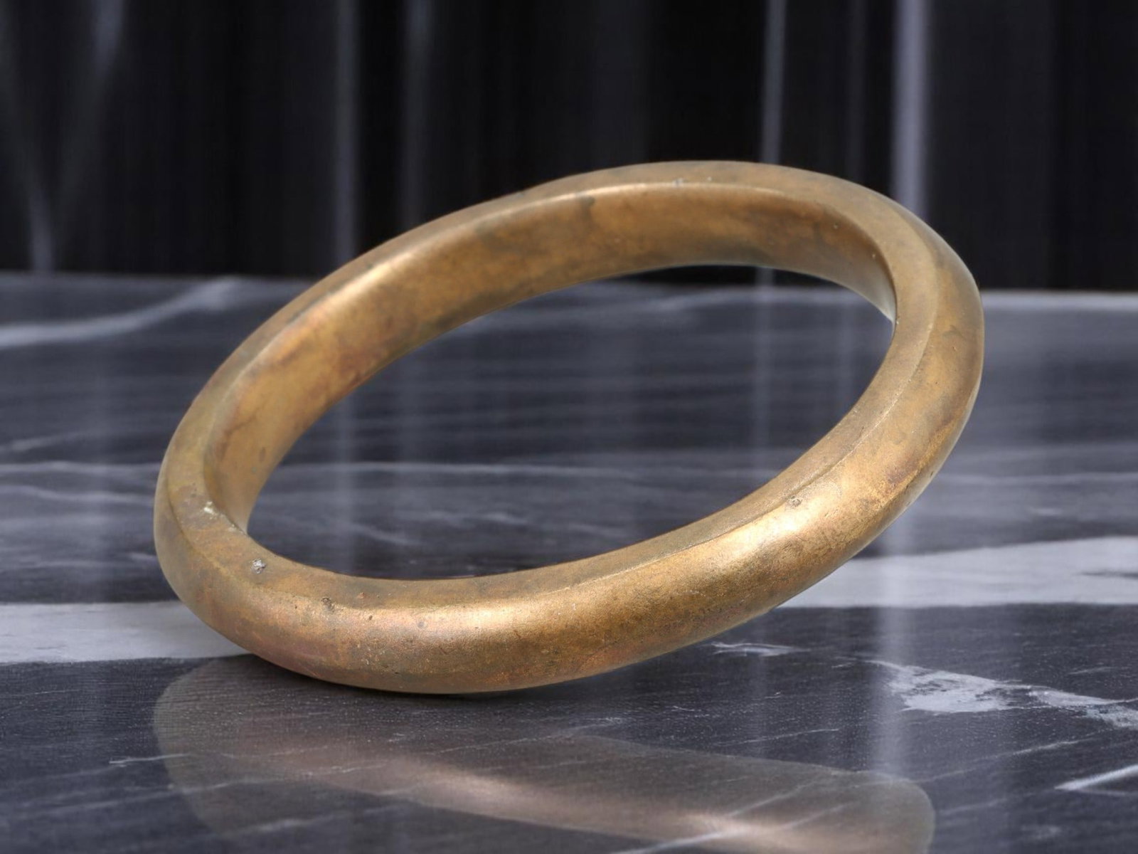 POST-MEDIEVAL Bronze Bangle - Smooth Rounded Form, Warm Patinated Finish (7.3 cm Inner Diameter): Minimal yet resonant, this solid bronze bangle features a smoothly contoured, fully rounded profile with a time-softened golden patina. The simplicity of its form speaks to utilitarian craftsmanship t