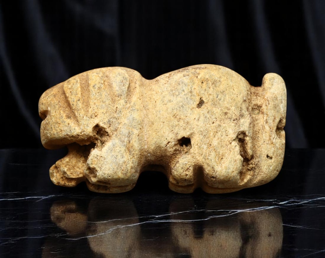 MESOPOTAMIA: Early Dynastic Period - Crouching Lion Zoomorphic Amulet, ca. 2900-2350 BCE, 34x17mm: Carved in the stylized form of a crouching lion, this compact zoomorphic amulet reflects the enduring Mesopotamian reverence for feline power as a symbol of kingship and divine protection. Rendered in