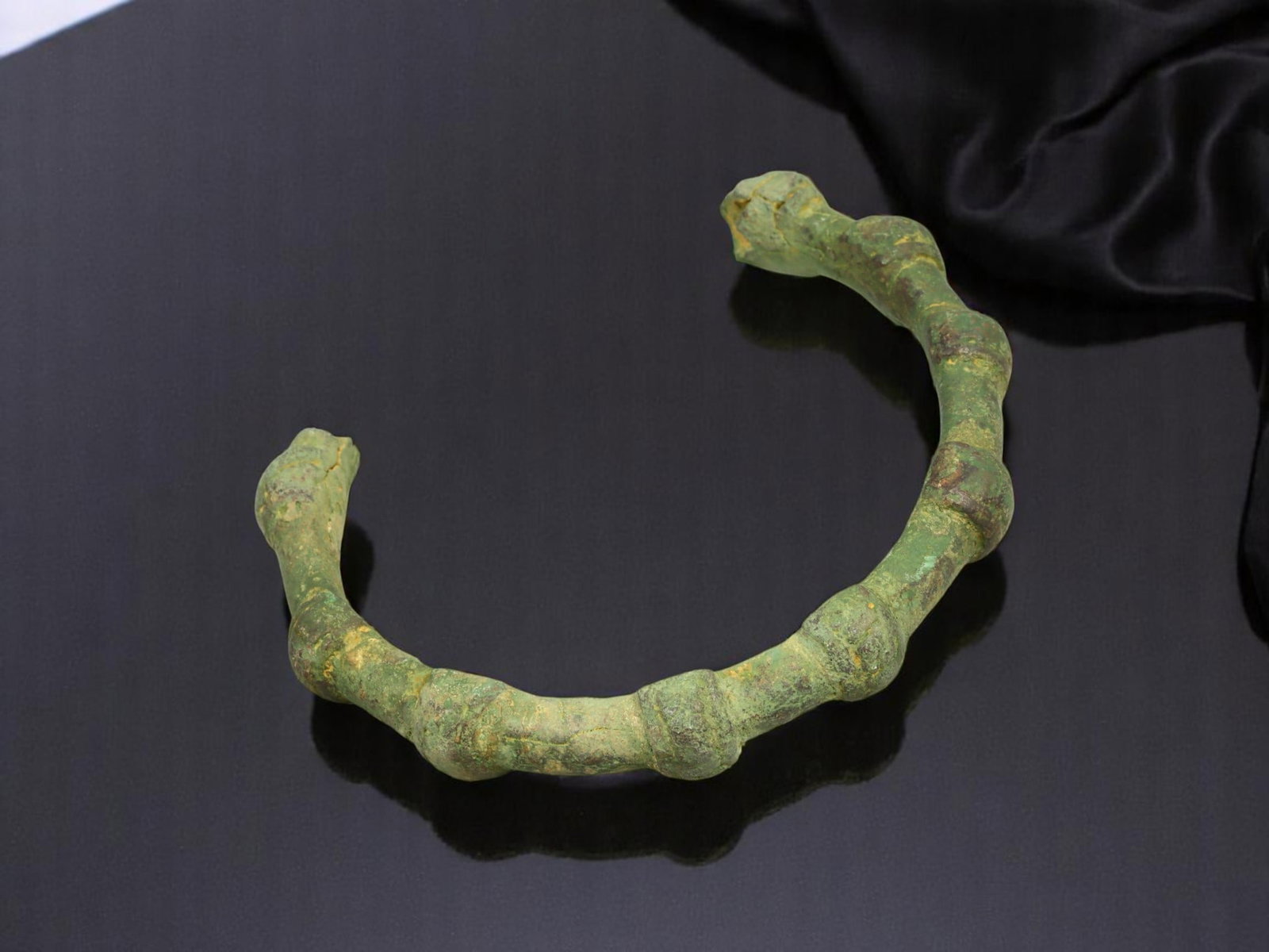 CELTIC Bronze Bracelet - Segmental Ridged Band, Open-Ended Form (7.2 cm): A sculptural artifact from the ancient Celtic world, this segmented bronze bracelet features a ridged, almost vertebral form with an open-ended structure. Its rhythmic bulges and aged green patina ref