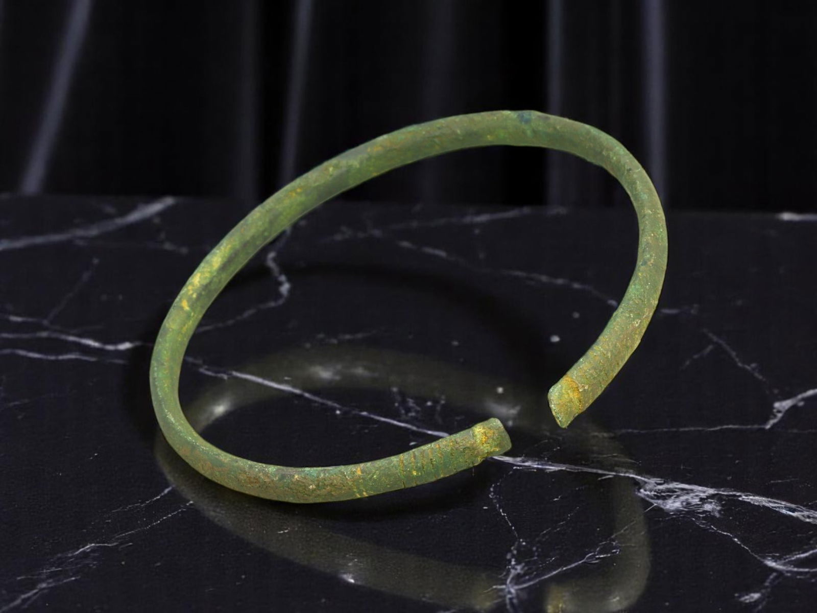 CELTIC Bronze Bracelet - Slender Tapered Band with Flattened Terminals, Open-Ended (7 cm): This minimalist Celtic bracelet features a fine, circular band subtly tapering toward gently flattened open terminals. The surface bears a soft green patina with specks of ochre, indicative of prolong