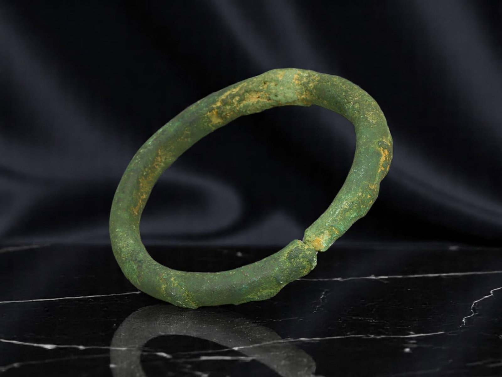 PROTO-CELTIC Bronze Bracelet - Crude Round Band with Irregular Seam Join (5 cm): This early proto-Celtic bracelet is formed from a thick, hand-shaped bronze rod, closed into a compact circle with a visible pressure-fitted seam. The surface bears uneven hammer marks and mineral-ric