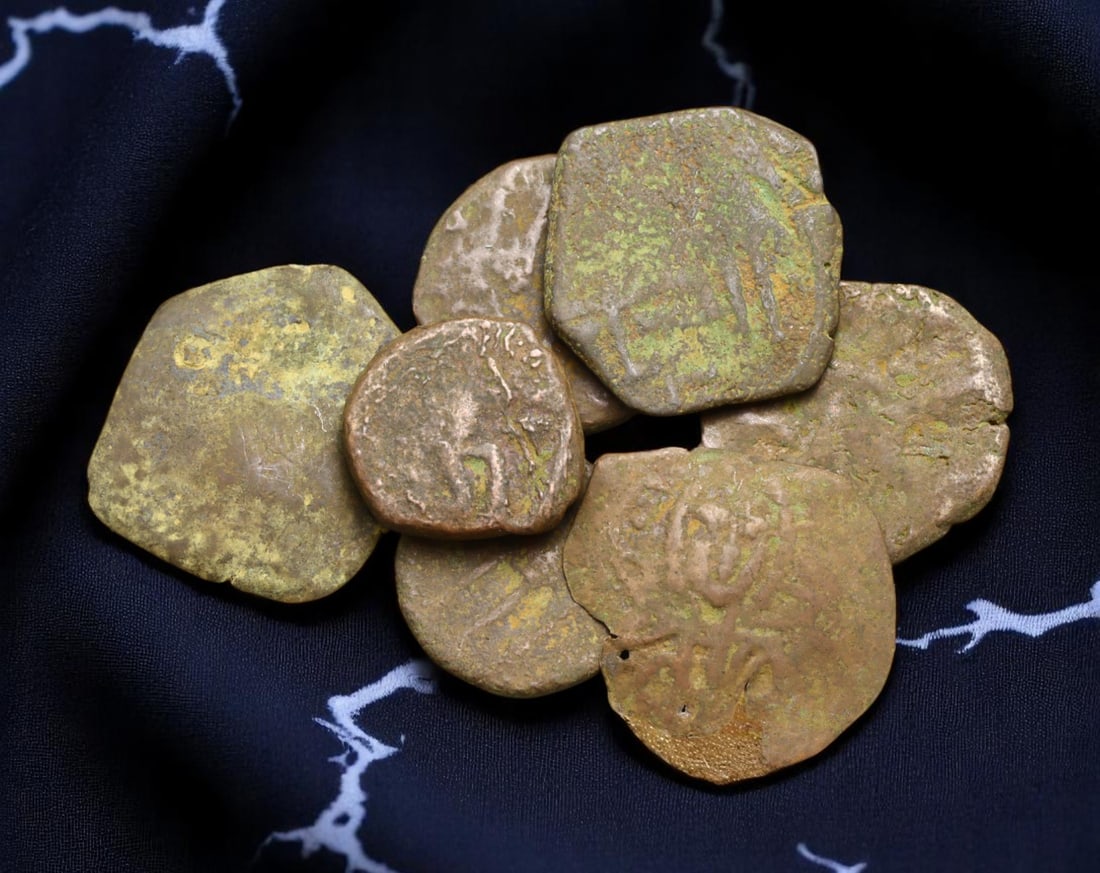 BYZANTINE EMPIRE: Lot of 7 Bronze Coins - Christian Iconography & Imperial Monograms, 11-18mm: This group of 7 Byzantine bronze coins offers a compelling window into the religious and political fusion of the Eastern Roman world. Despite surface wear and earthen encrustation, traces of imperial