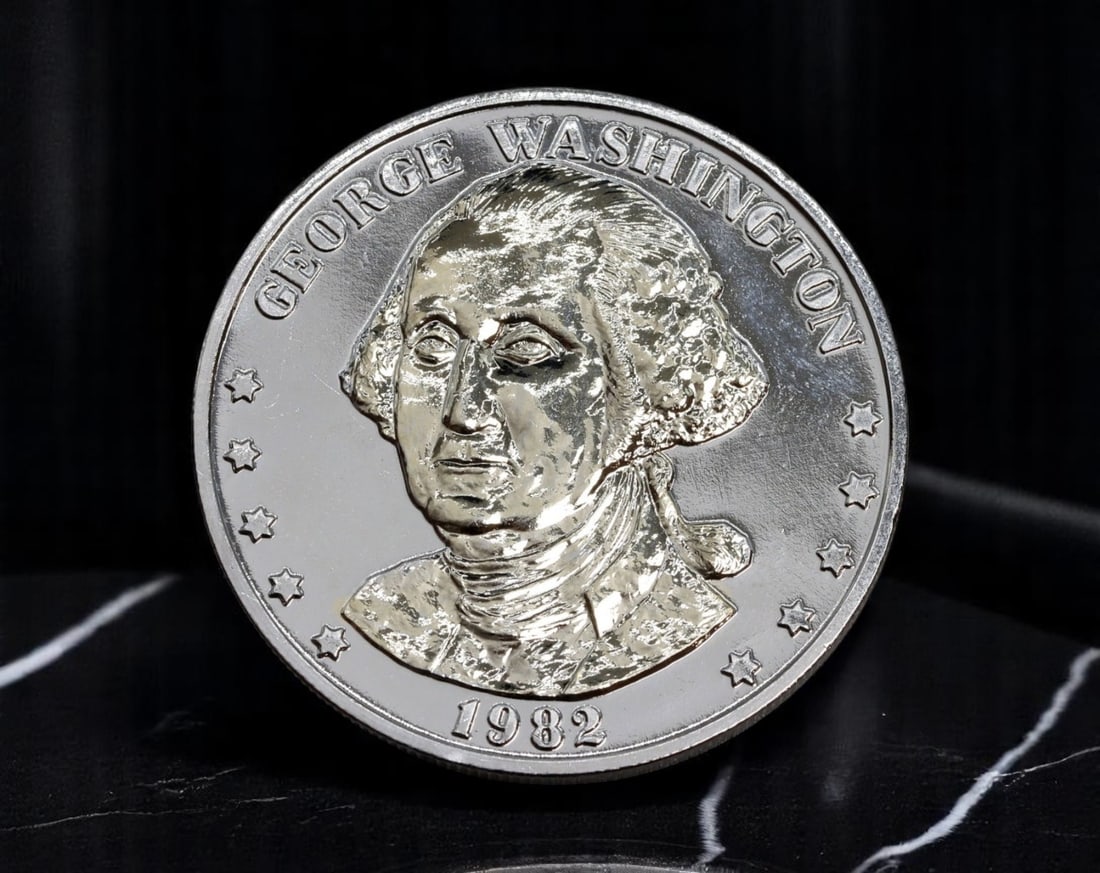 USA: George Washington - 250th Anniversary Commemorative Gilt Coin, 1982 (39mm): Issued in 1982 to honor the 250th anniversary of George Washington's birth in 1732, this high-relief commemorative coin features a gilt bust of Washington in formal attire, surrounded by thirteen star