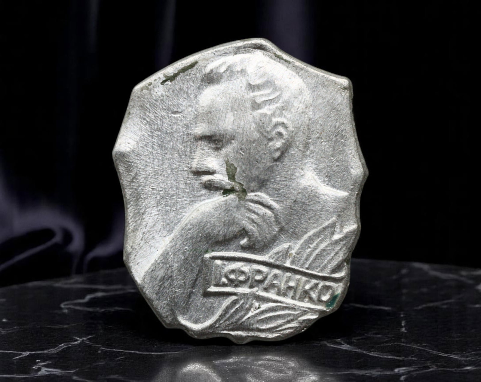 USSR: Ivan Franko Ukrainian Literary Commemorative Badge, 1970s, 22x18mm: This sculptural badge pays homage to Ivan Franko, one of Ukraine's greatest literary figures and political thinkers. Cast in textured silver-tone metal with an organic, irregular border, the profile o