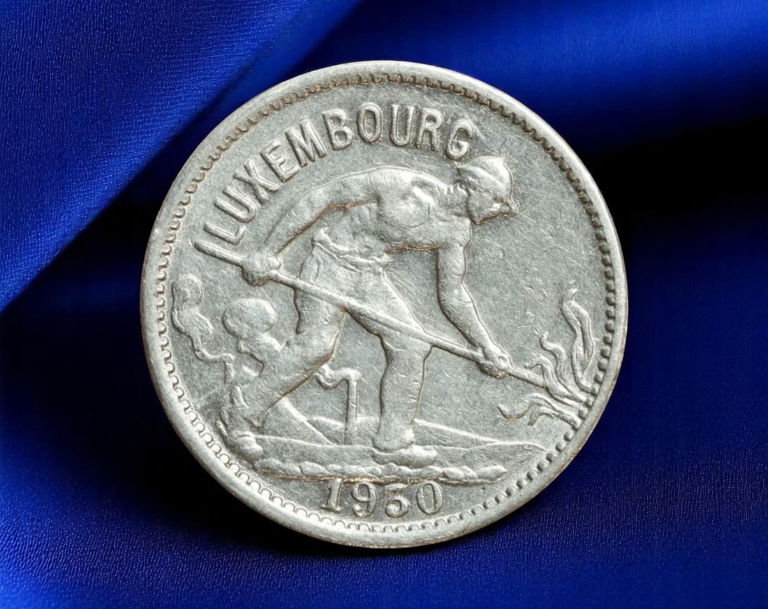 LUXEMBOURG: Postwar Renewal - Agricultural Revival 50 Centimes Coin, 1950, 19mm: Struck in 1950 as part of Luxembourg's postwar economic stabilization, this 50 centimes coin encapsulates national resilience through the allegory of labor. A muscular blacksmith, captured mid-strike 