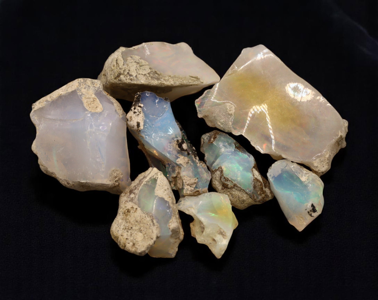 GEM LOT: Ethiopian Welo Opal Rough - Iridescent Play-of-Color in Matrix, Mixed Forms (15g): An estate-sourced parcel of natural Ethiopian Welo Opal rough, totaling 11 grams, this lot features raw, matrix-hosted specimens with vibrant play-of-color across milky, translucent, and honey-toned b