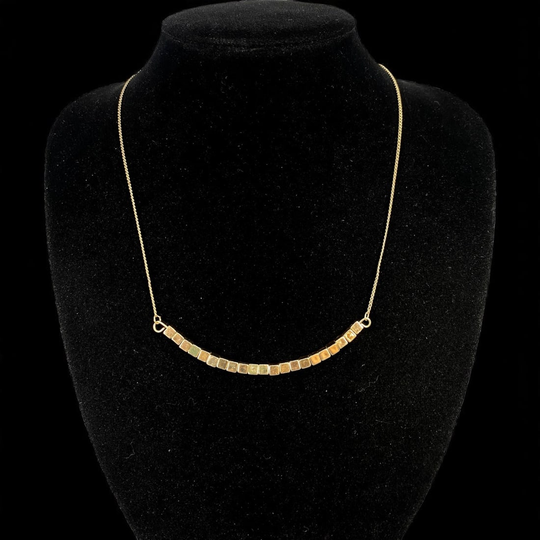 Necklace - Graduated Square Tiles in Polished Goldtone (54cm): Sleek and quietly sculptural, this 54 cm necklace features a refined curve of goldtone square tiles-each with a subtly rounded edge-strung in a gentle arc along a fine goldtone chain. The design evoke