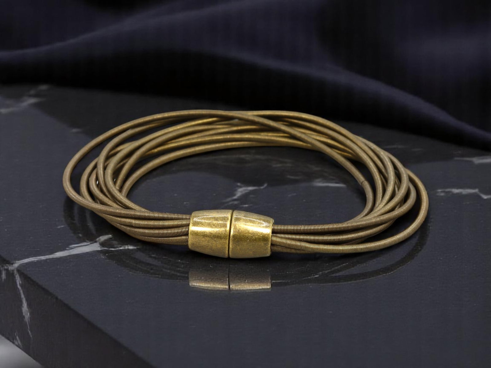LATE 20TH CENTURY: Estate Coil Bracelet - Multi-Strand Bronze-Tone Wire with Magnetic End Caps, 8cm: A distinctive estate jewelry piece from the late 20th century, this multi-strand coil bracelet features bronze-tone flexible wire bands secured with modernist-style magnetic end caps. The circular cap