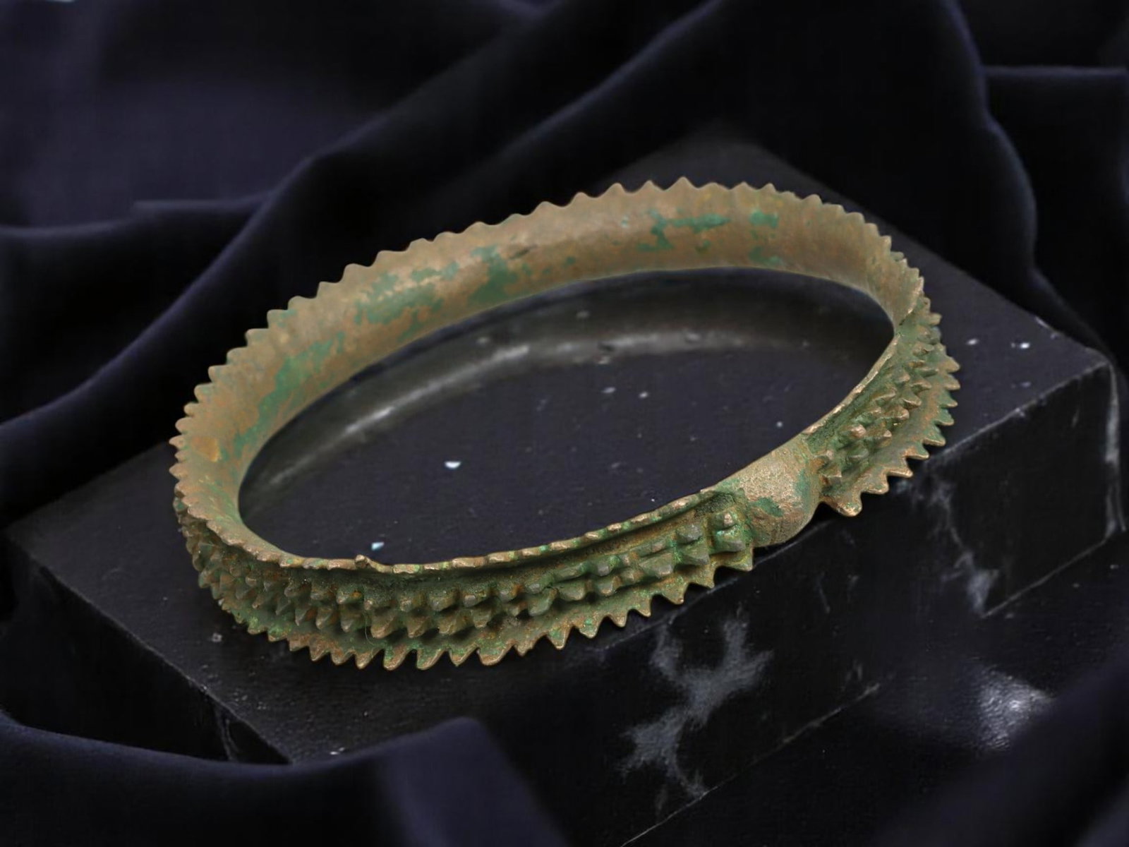 AFRICAN TRIBAL / EARLY POST-MEDIEVAL Spiked Bronze Currency Bracelet, 7.3 cm: Cast with extraordinary texture and form, this tribal bronze bracelet features a bold ring of radial triangular teeth and central nodular ridging, echoing the ceremonial and monetary use of adornment 
