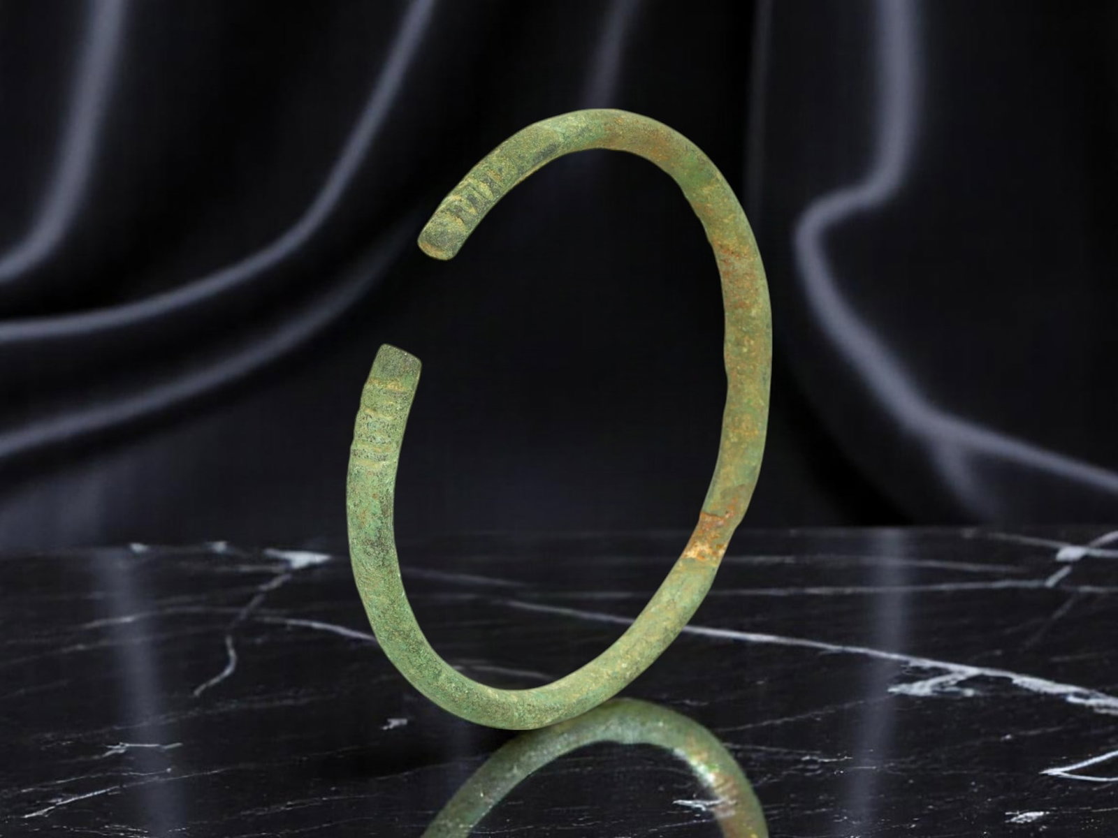 ANCIENT CELTIC / ROMAN PROVINCIAL Scroll-Terminal Bronze Bracelet, 6.2 cm: Refined in proportion and ornament, this ancient bronze bracelet features squared terminals etched with shallow scroll and rib motifs-design elements tied to both decorative and communicative practice