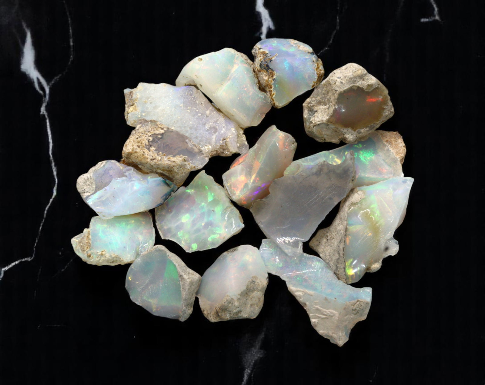 GEM LOT: Ethiopian Welo Opal Rough - Iridescent Play-of-Color in Matrix, Mixed Forms (8g): An estate-sourced parcel of natural Ethiopian Welo Opal rough, this lot features raw, matrix-hosted specimens with vibrant play-of-color across milky, translucent, and honey-toned bodies. Flashes of g