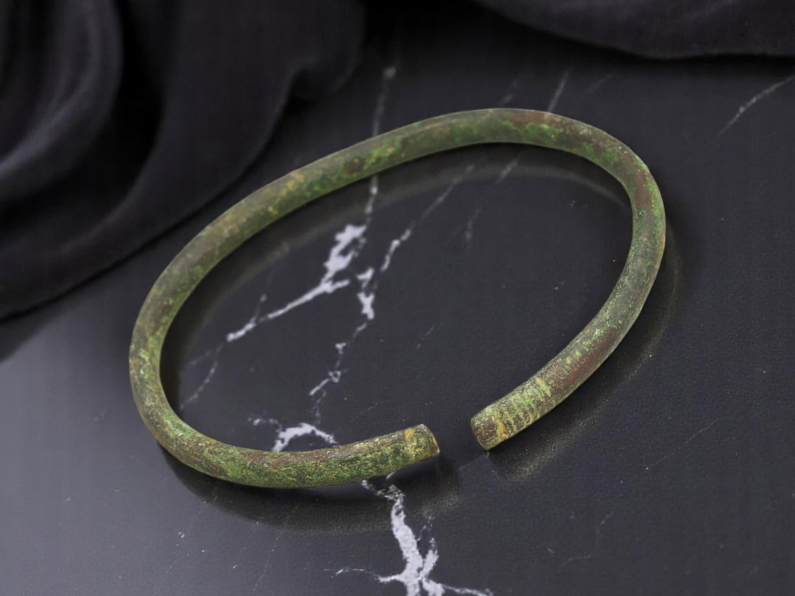 PROTO-CELTIC Bronze Bracelet - Light Ribbed Terminals, 5.7 cm: This 5.7 cm proto-Celtic bracelet embodies the tactile strength of early European metallurgy. Forged in a simple arc, the slender band terminates in squared ends etched with fine linear ribs-suggestiv