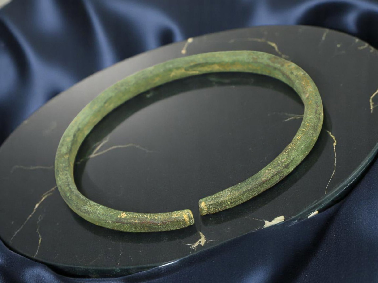 PROTO-CELTIC Bronze Open-Ended Bracelet - Weathered Arc Form, 7 cm: A robust artifact of early metallurgy, this open-ended bracelet (7 cm diameter) reflects the utilitarian refinement characteristic of proto-Celtic ornamentation. Cast in solid bronze and aged to a sof