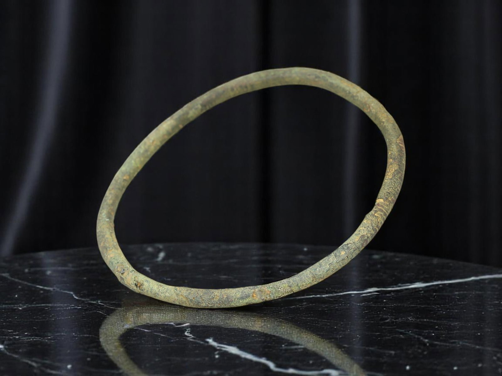 ANCIENT ROMAN Continuous Bronze Armlet with Textured Patina, 6.3 cm: This slender Ancient Roman bracelet presents a continuous circular band form with soft surface irregularities and an aged, matte verdigris patina. Measuring 6.3 cm in diameter, its minimalist profile 