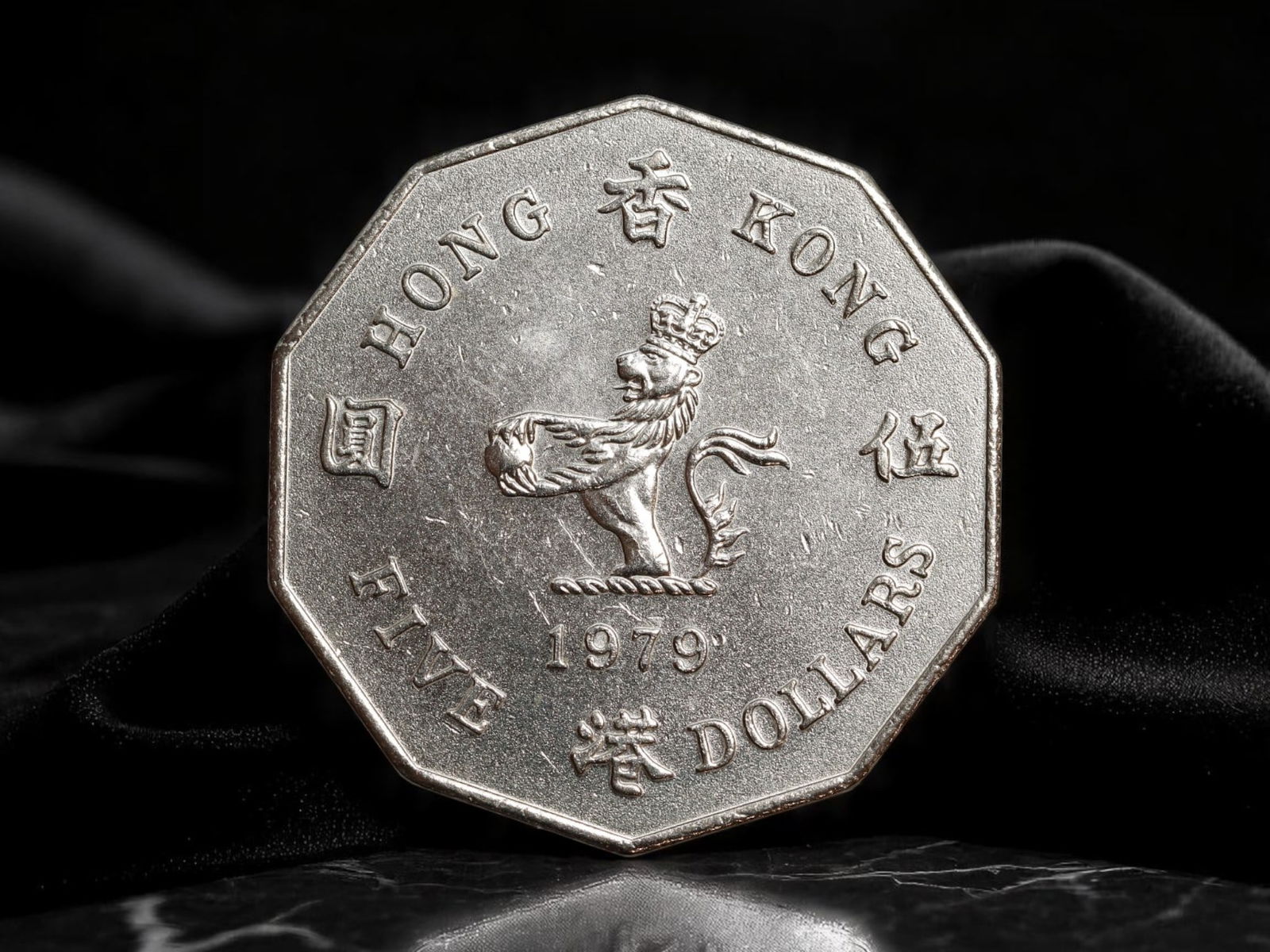 HONG KONG: Colonial Heraldry - Royal Lion 5 Dollars Coin, 1979, 30mm: Issued in 1979 under British colonial administration, this 5 Dollars coin from Hong Kong presents a striking blend of imperial iconography and regional currency identity. The obverse features a crowne