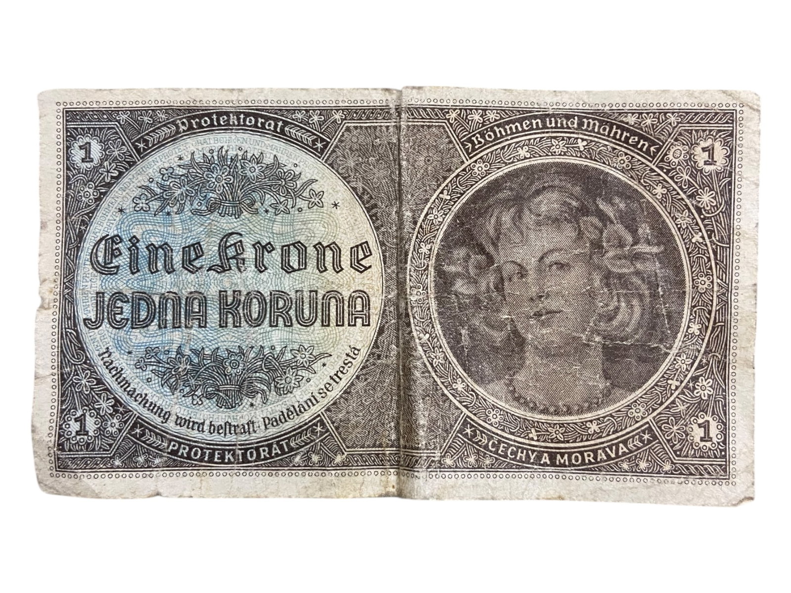 BOHEMIA AND MORAVIA: Occupation Currency - Protectorate 1 Krone Banknote, 1940: Issued under Nazi occupation, this 1 Krone banknote from the Protectorate of Bohemia and Moravia is a stark emblem of imposed authority cloaked in regional aesthetic. The note balances dual-language i