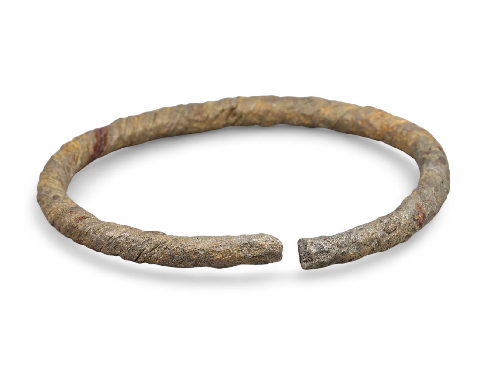 Ancient Celtic Spiral Motif Open-Ended Iron Bracelet, c. 3rd-1st Century BCE: This powerful open-ended bracelet originates from the ancient Celtic world, dating approximately to the 3rd-1st century BCE. Forged in iron and bearing the characteristic spiral grooves of Celtic meta
