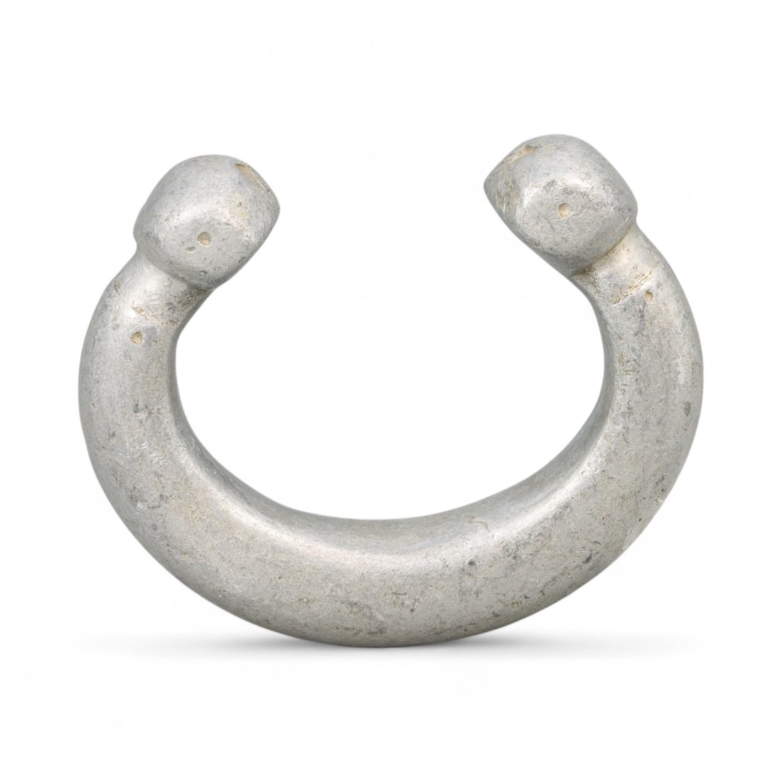 Post-Medieval West African Aluminum Trade Bracelet, c. 18th-19th Century CE: This striking 18th-19th century West African bracelet, cast in aluminum, reflects a deep tradition of adornment and trade-based craftsmanship. Measuring 7.2 cm (2.83 in) in diameter and weighing 66 gr