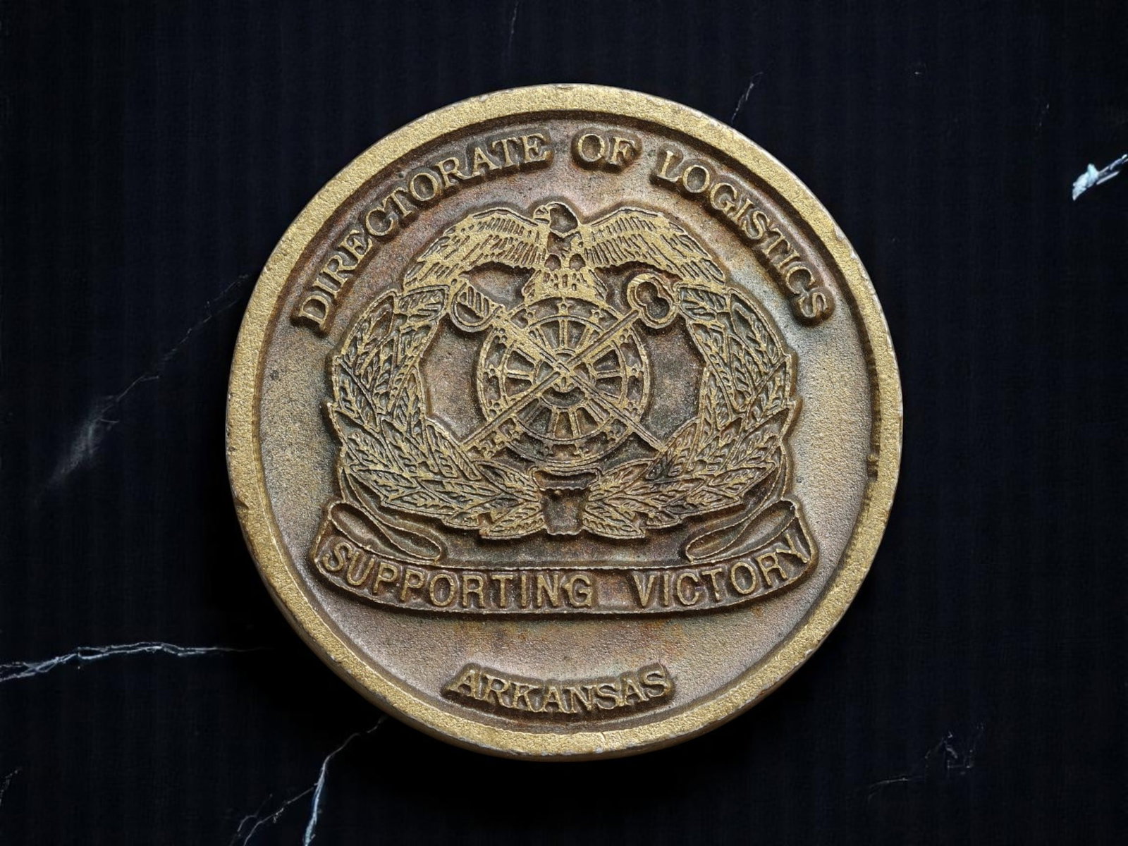 UNITED STATES: Directorate of Logistics Challenge Coin, Arkansas, 20th Century, 37mm: This robust 37mm bronze-toned challenge coin represents the enduring ethos of logistical excellence within the U.S. military apparatus. Issued by the Directorate of Logistics in Arkansas, the obverse 