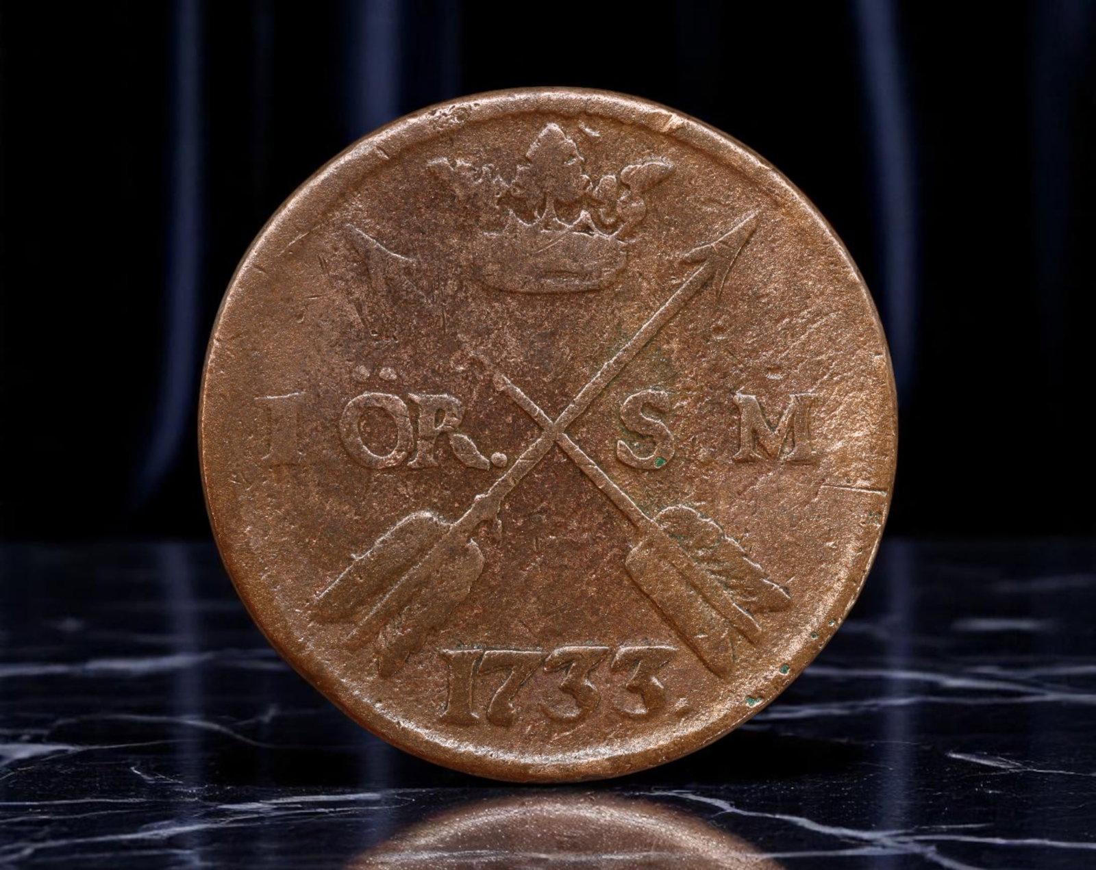 SWEDEN: Frederick I - Royal Arms and Crossed Arrows Copper 1 Ore Coin, 1733, 30mm: Struck in the midst of Sweden's Age of Liberty, this 1733 copper 1 Ore coin radiates both martial symbolism and monarchical pride. The obverse bears the entwined, crowned monogram of King Frederick I 