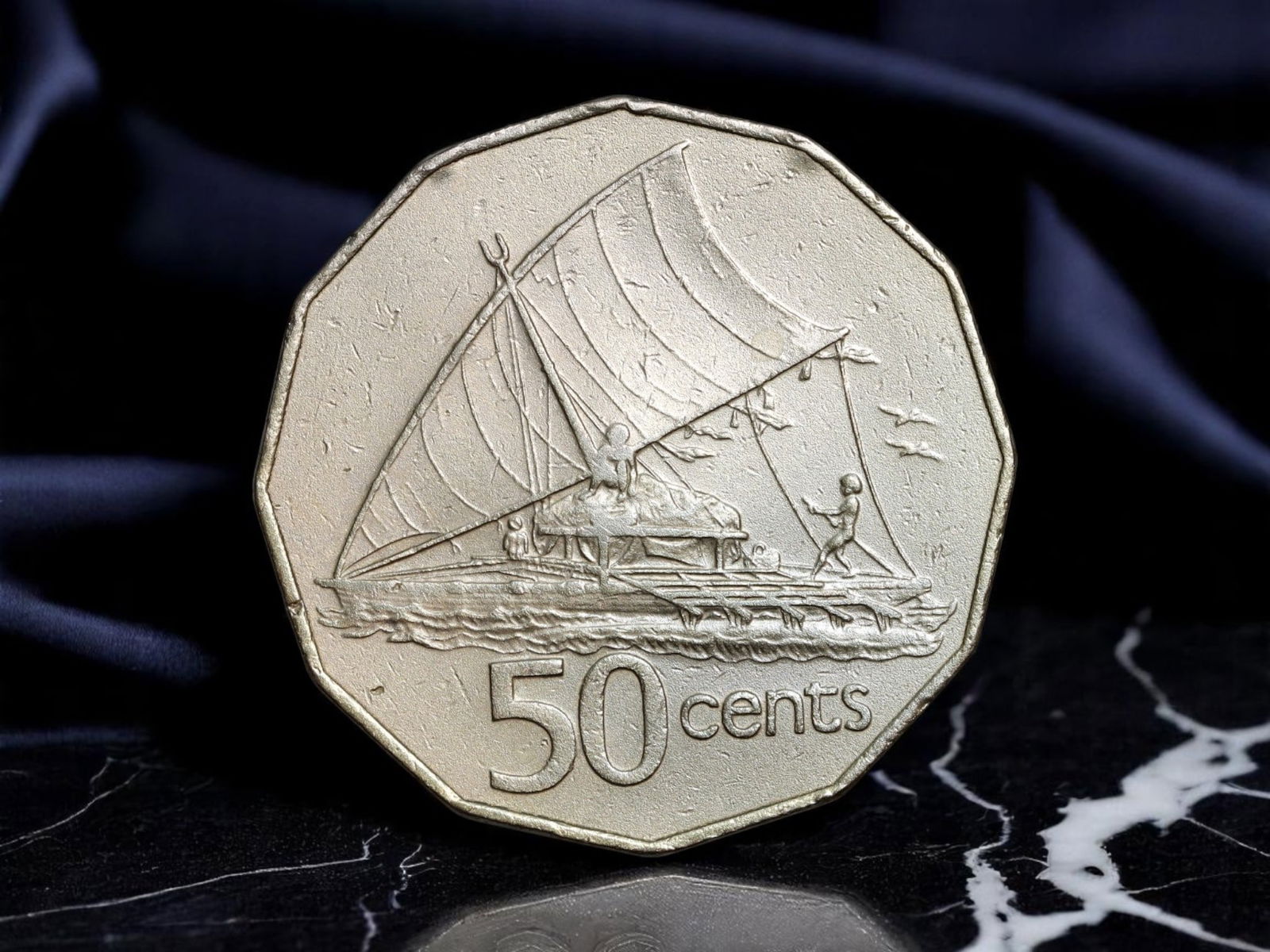 FIJI: Island Sovereignty - Elizabeth II 50 Cents Coin, 1981, 32mm: This 1981 Fijian 50 cents coin celebrates maritime heritage and constitutional monarchy through striking dual symbolism. One side portrays a traditional drua canoe under full sail, a powerful homage t