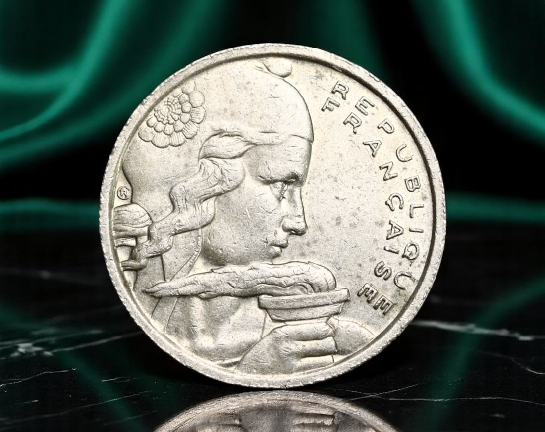 FRANCE: Marianne - Liberty Torch 100 Francs Coin, 1957 (23mm): Issued during the waning years of the French Fourth Republic, this 23mm 100 Francs coin beautifully portrays Marianne, the national personification of liberty and reason. On the obverse, she is shown 
