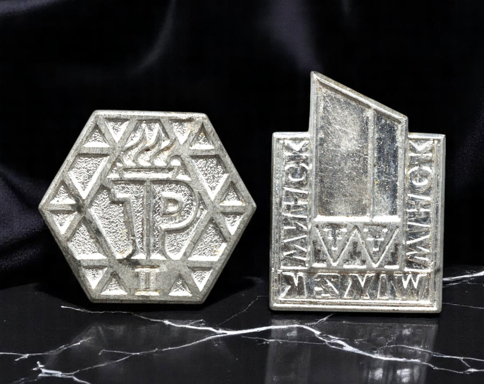 POLAND: Industrial Progress and Katowice Trade Fair Commemorative Badges, 1970s, 19-22mm: These two boldly geometric badges celebrate the industrial and economic achievements of socialist Poland. The hexagonal badge, emblazoned with the monogram "JP" beneath a torch, evokes the ideals of l