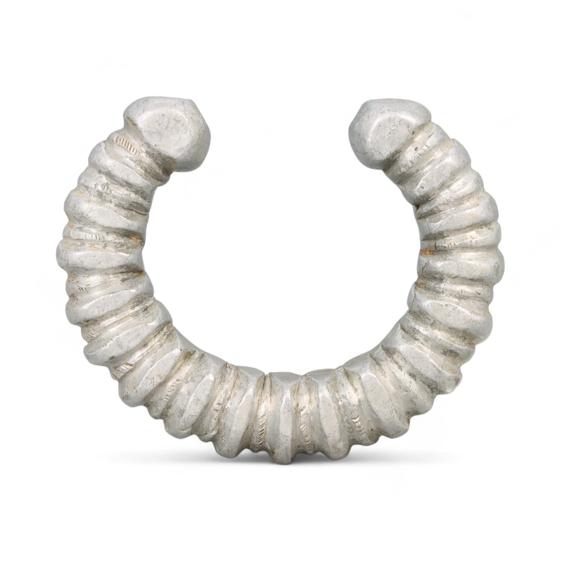 Post-Medieval West African Ribbed Aluminum Currency Bracelet, c. 18th-19th Century CE: This robust aluminum bracelet from West Africa, dating to the 18th-19th century CE, embodies the intersection of art, wealth, and cultural identity. With a weight of 77 grams (2.72 oz) and an outer di