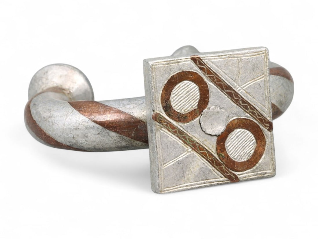 Antique North African Cosmic Rings Motif Bi-Metallic Bracelet, c. 18th-19th Century CE: Evocative of a celestial diagram rendered in metal, this North African bracelet from the 18th-19th century CE encapsulates both ornamental finesse and symbolic gravitas. Weighing 54 grams (1.9 oz) and