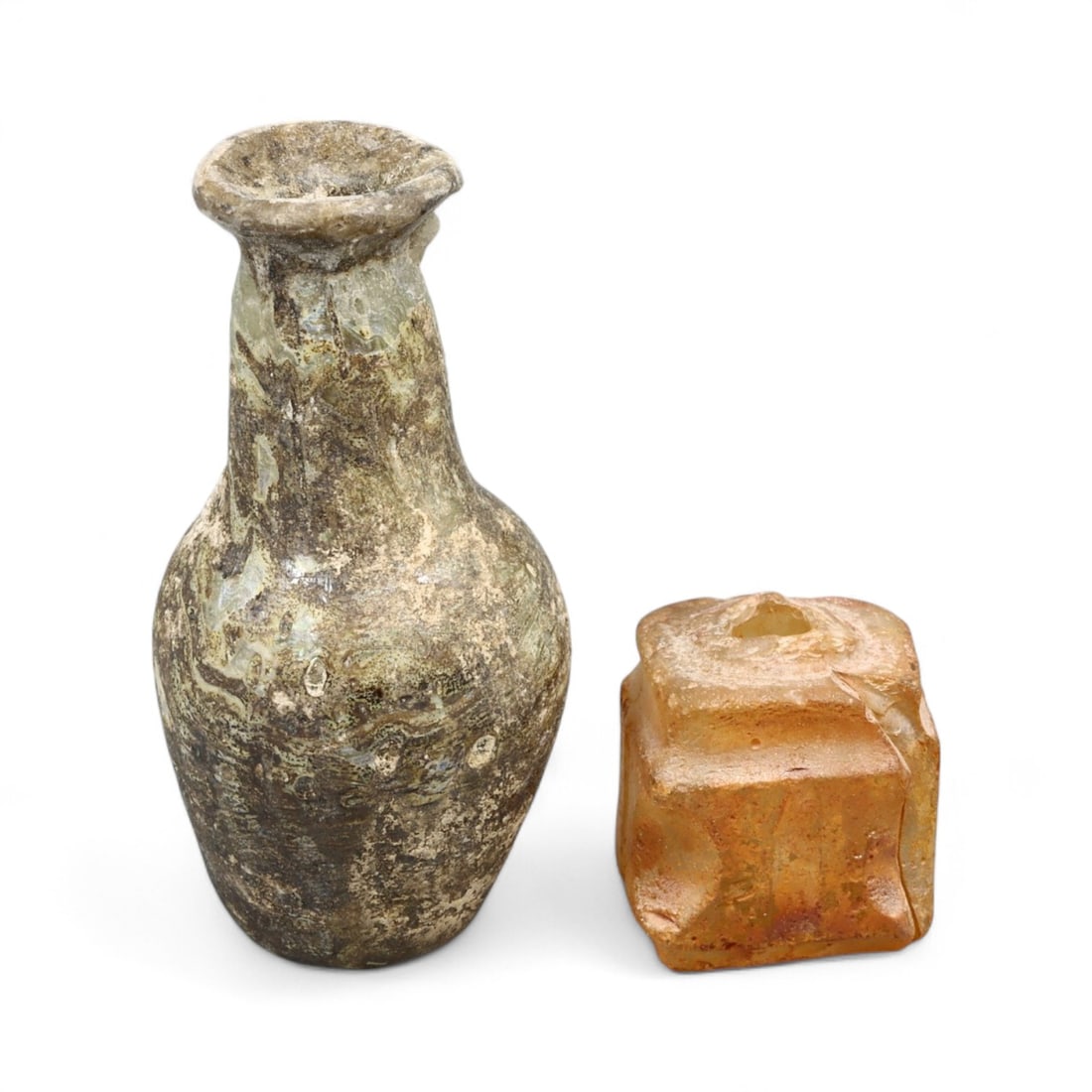 Ancient Roman Mold-Blown and Freeform Glass Flask Pair, c. 1st-3rd Century CE: This authentic pair of Ancient Roman glass flasks offers a glimpse into the artistry and functionality of Roman daily life. Measuring approximately 2.1 x 1.2 inches (5.5 x 3 cm), these two vessels rep